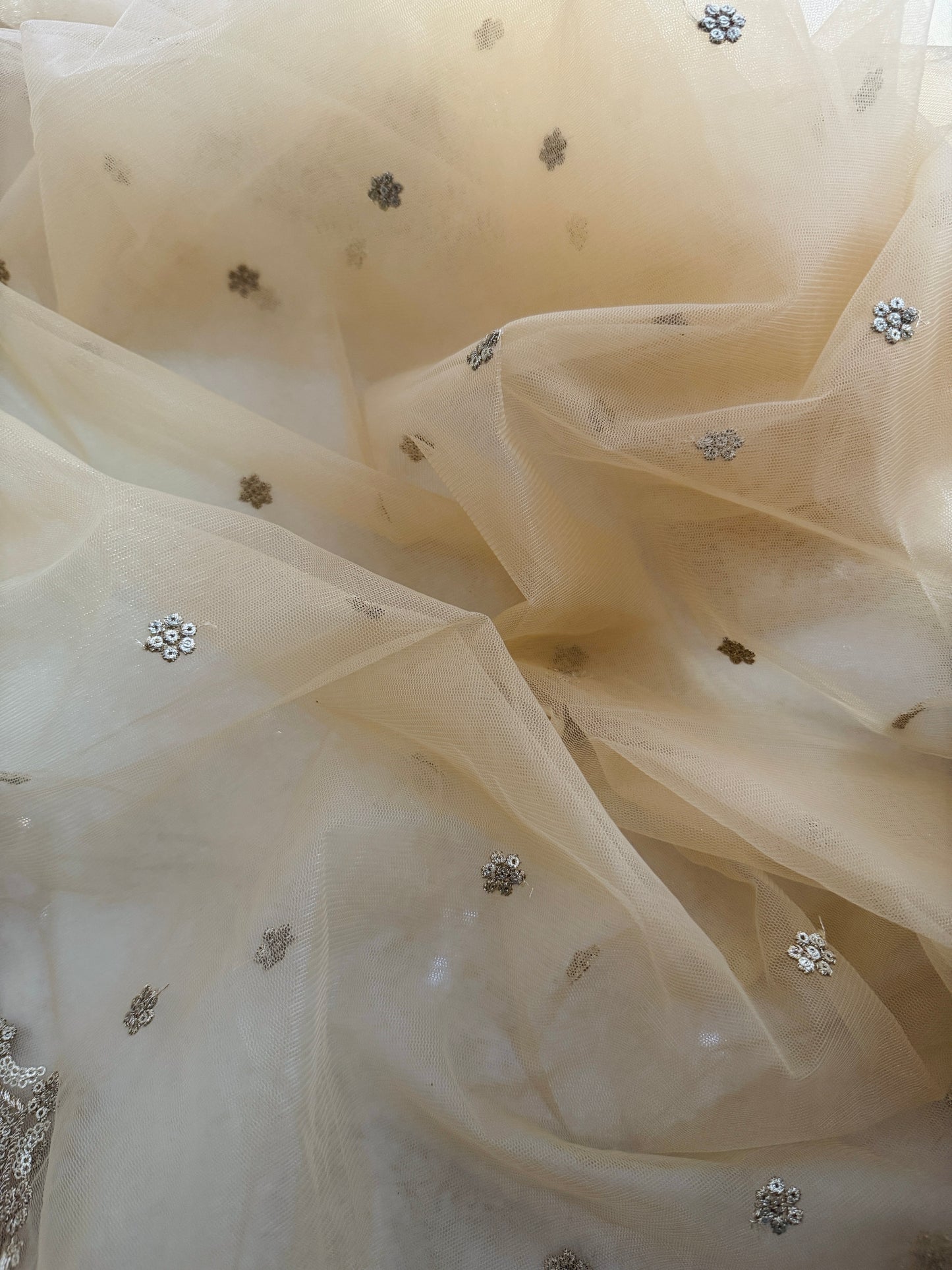 Close-up view of zari and mirror handwork on golden net bridal dupatta